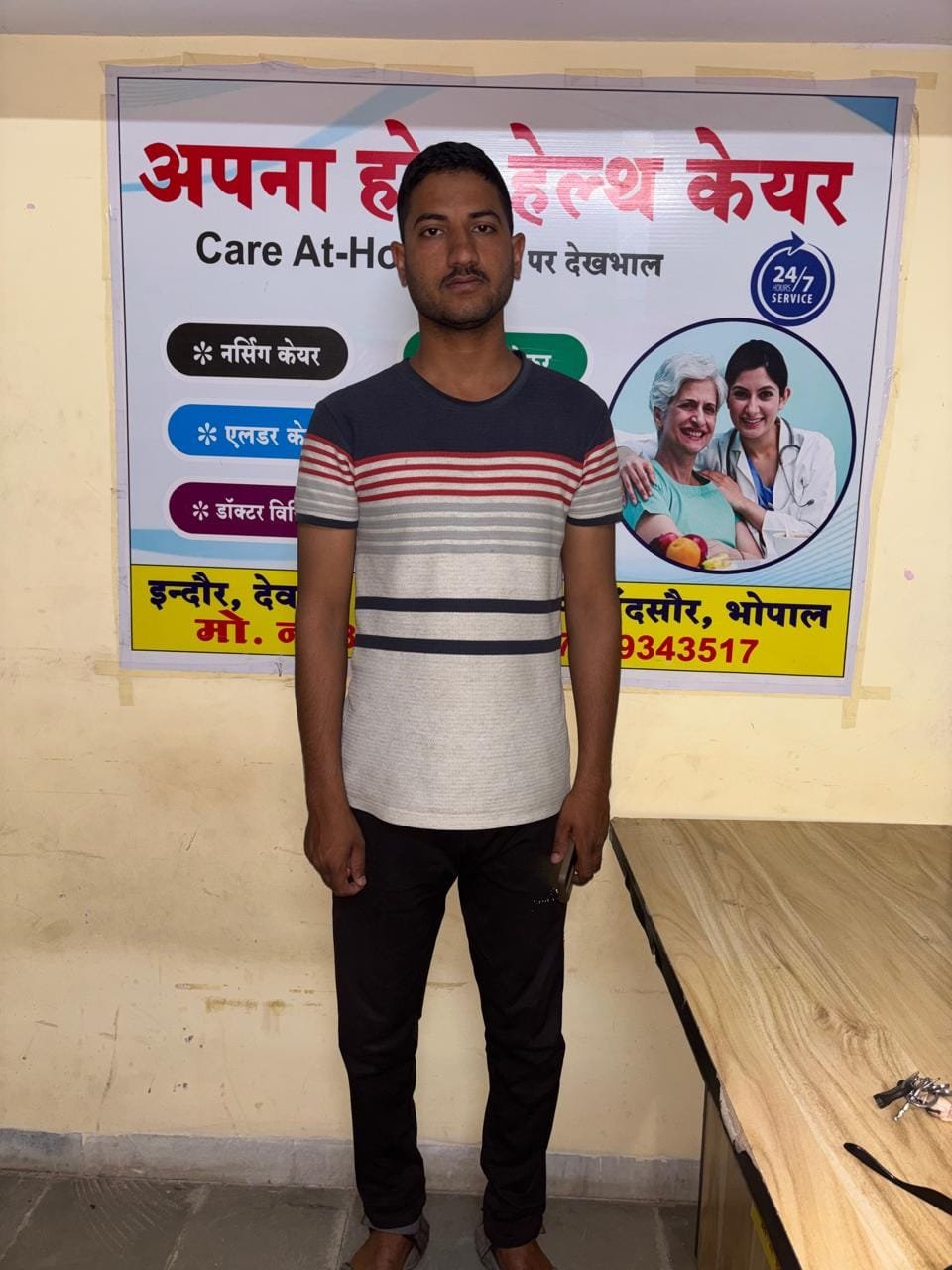 Staff member standing with company poster